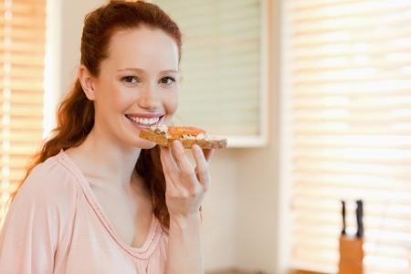 vrouw eet boterham met gezond beleg