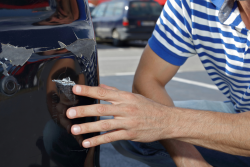 Man wijst naar lakschade op auto